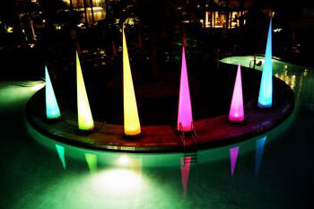 various sizes of LED lit cones in colors of blue, green, yellow and red around a pool - Airstar America rental for hotel - Orlando, Florida USA