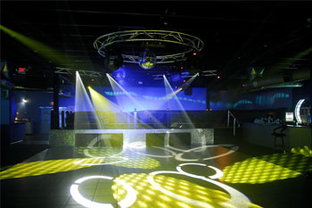 dance floor with disco ball, 4 white beams of light projecting  geometric circle gobos, and yellow beams of light projecting geometric dots gobos from Techni-Lux Trackers  Aqua Lounge, Daytona Beach, Florida