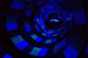 illuminated hues of blue on alternate striped round walls of the inside Brainwash Water Slide, Wet 'n Wild - Orlando, Florida, USA