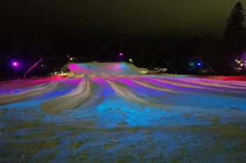 vibrant colors of pink, purple, red royal blue and aqua from LED fixutres illuminating the snow at Lunar Lights Tubing Peek 'n Peak Resort - Clymer, New York U.S.A.