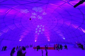 synched to music LED light show in hues of purple and pink with snowflake patterned gobos illuminated in white inside Artic Igloo at Snowcat Ridge Alpine Snow Park - Dade City, Florida, USA