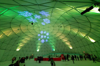 synched to music LED light show in hues of green and yellow with snowflake patterned gobos illuminated in white inside Artic Igloo at Snowcat Ridge Alpine Snow Park - Dade City, Florida, USA