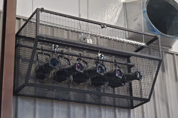 mulitple ellipsoidal fixtures protected in metal cage in Gymnatorium at Martin Luther King Jr. Junior High, Monroe, Louisiana, USA